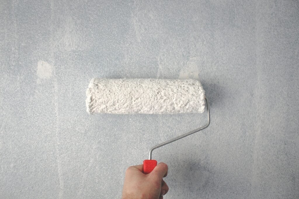paint roller painting on wall